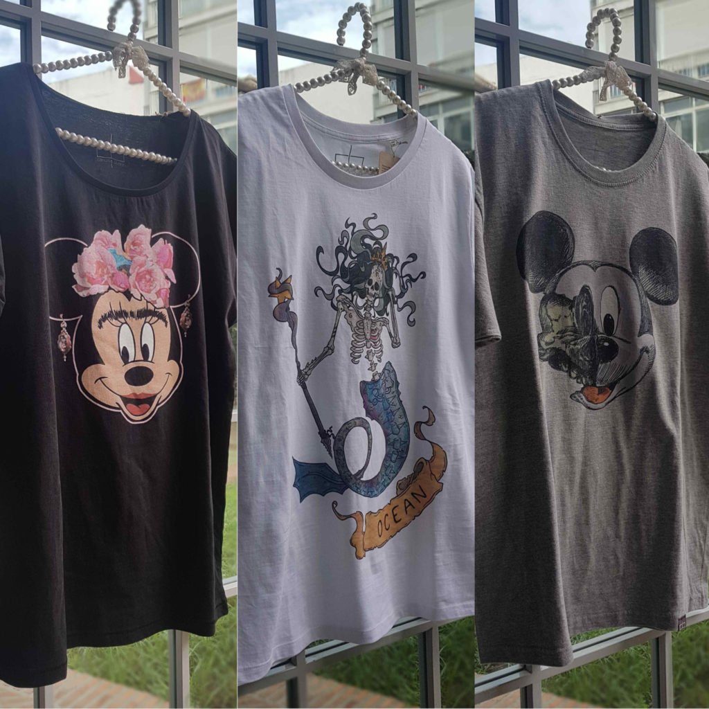 Three T-shirts hanging on a rack